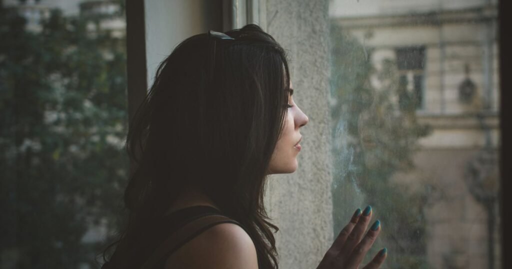 woman sitting alone in the dark thinking about being the other woman