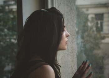 woman sitting alone in the dark thinking about being the other woman