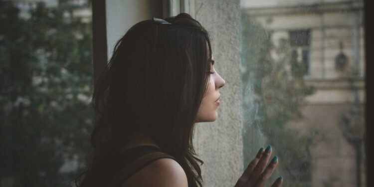 woman sitting alone in the dark thinking about being the other woman