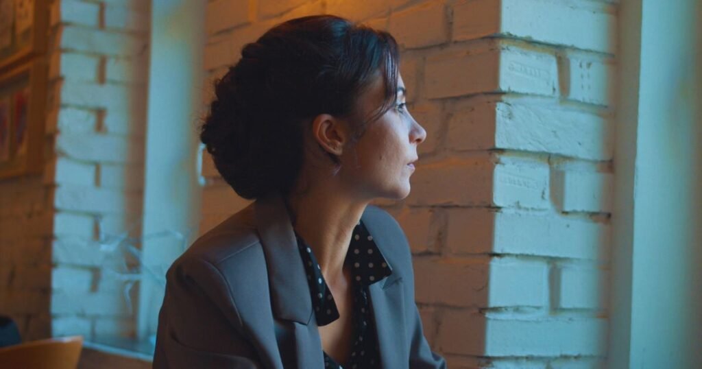 Woman looking out the window feeling emotionally drained in a toxic relationship with a narcissist.